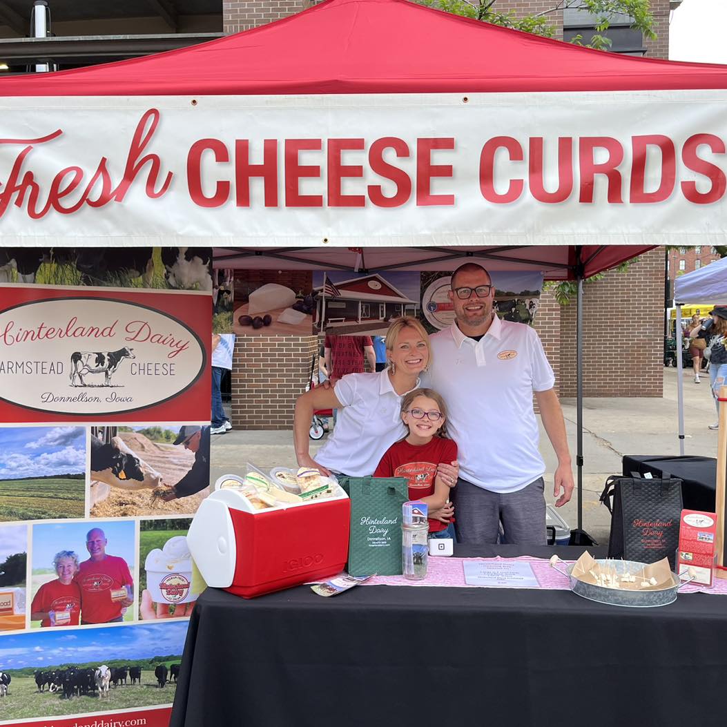 People at an outdoor market selling cheese